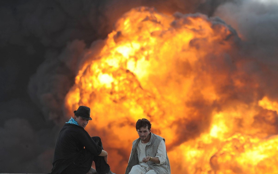 Những người đàn ông Afghanistan chứng kiến cảnh một tàu chở nhiên liệu phát nổ ở Kabul ngày 4/8/2011. (Nguồn: AFP/TTXVN)