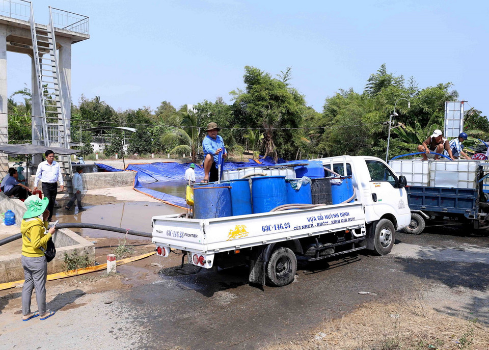 Người dân trên địa bàn xã Thanh Hòa, thị xã Cai Lậy đến lấy nước ngọt miễn phí tại điểm cung cấp nước ngọt cầu Ông Thiệm. (Ảnh: Vũ Sinh/TTXVN)