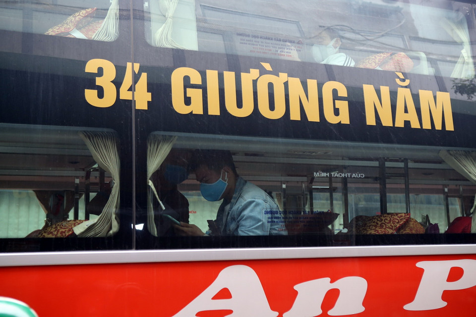 Hành khách tại bến xe Nước Ngầm (Hà Nội), được nhân viên nhà xe hướng dẫn khai báo y tế trên ứng dụng ''Vietnam Health Declaration.'' (Ảnh: Danh Lam/TTXVN)