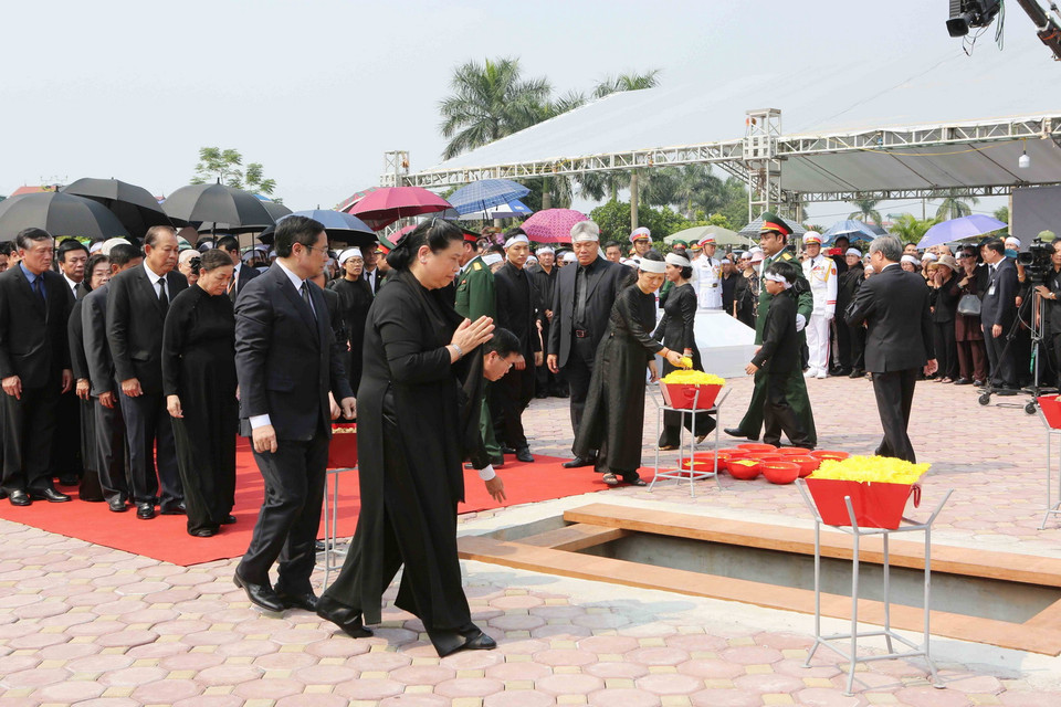 Các đồng chí lãnh đạo, nguyên lãnh đạo Đảng, Nhà nước, Mặt trận Tổ quốc Việt Nam thả những nắm đất đầu tiên xuống huyệt mộ nguyên Tổng Bí thư Đỗ Mười. (Ảnh: Dương Giang/TTXVN)