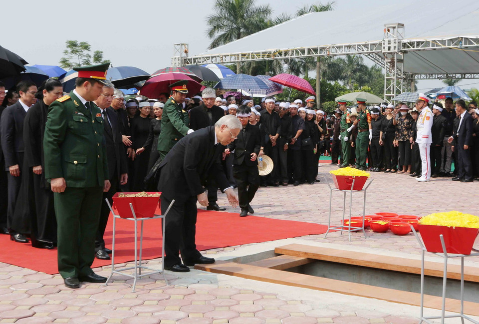 Tổng Bí thư Nguyễn Phú Trọng dẫn đầu đoàn các đồng chí lãnh đạo, nguyên lãnh đạo Đảng, Nhà nước, Mặt trận Tổ quốc Việt Nam thả những nắm đất đầu tiên xuống huyệt mộ nguyên Tổng Bí thư Đỗ Mười. (Ảnh: Dương Giang/TTXVN)