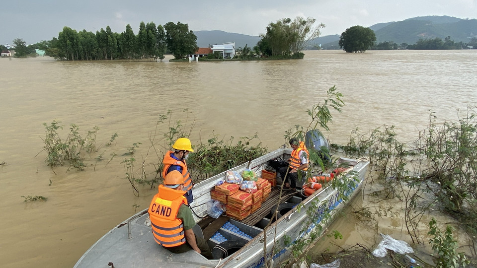 Công an huyện Tuy Phước, tỉnh Bình Định, dùng canô chở nhu yếu phẩm qua cho người dân vùng lũ xã Phước Nghĩa. (Ảnh: Tường Quân/TTXVN)