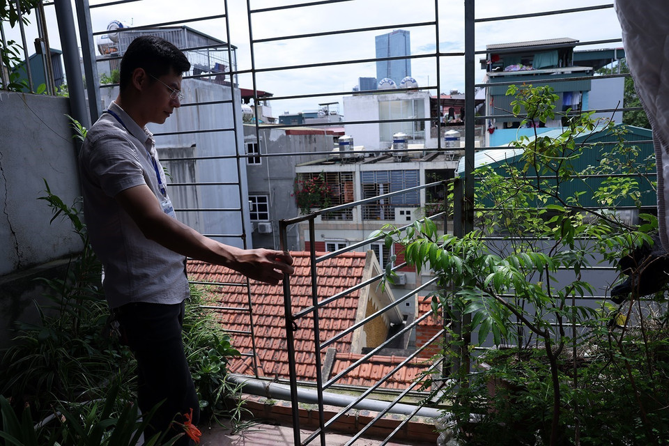Kiểm tra cửa thoát hiểm trên tầng tum của một khu nhà trọ trên đường Nguyễn Khánh Toàn, phường Quan Hoa. (Ảnh: Tuấn Anh/TTXVN)