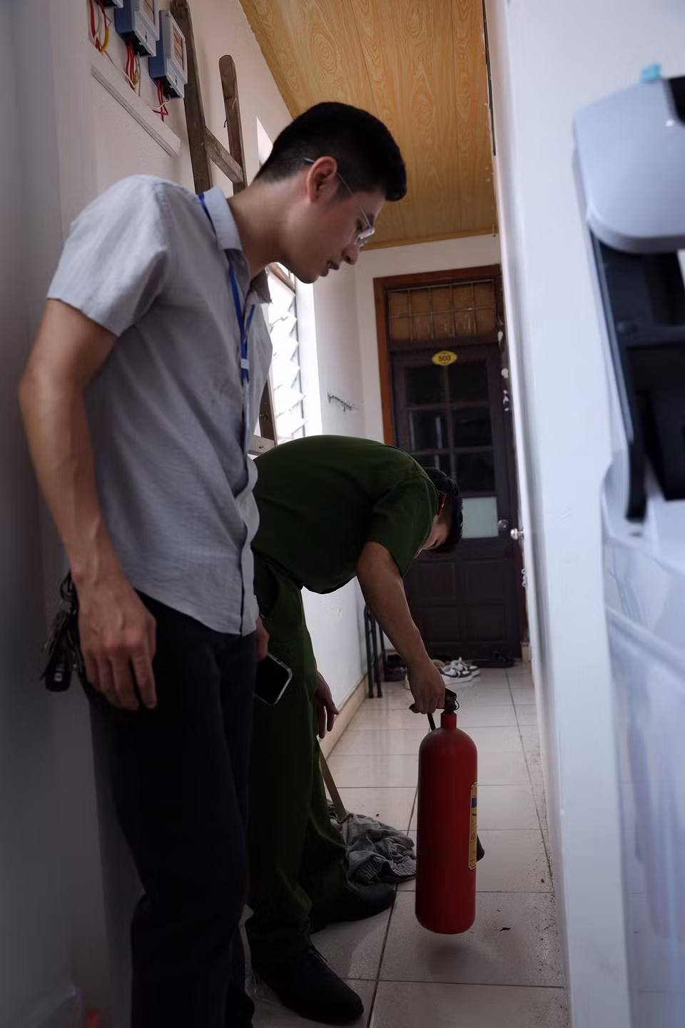 Cán bộ Phòng cháy chữa cháy quận Cầu Giấy kiểm tra bình cứu hỏa tại các khu nhà trọ. (Ảnh: Tuấn Anh/TTXVN)