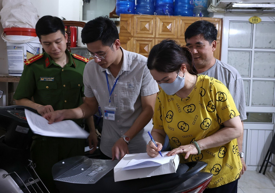 Chủ nhà trọ ký cam kết biên bản an toàn phòng chống cháy nổ tại khu nhà trọ. (Ảnh: Tuấn Anh/TTXVN)