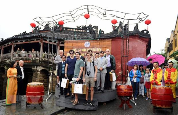 Du khách quốc tế chụp ảnh lưu niệm tại Chùa Cầu, Hội An, Quảng Nam. (Ảnh: Nguyễn Sơn/TTXVN) Hạn chế khách tham quan Chùa Cầu ở Hội An nhằm chống quá tải ảnh 1
