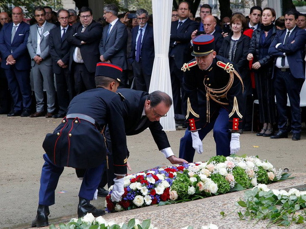 Tổng thống Pháp François Hollande đặt hoa tưởng nhớ các nạn nhân. (Nguồn: Reuters) Pháp tưởng niệm các nạn nhân trong các vụ tấn công khủng bố ảnh 1