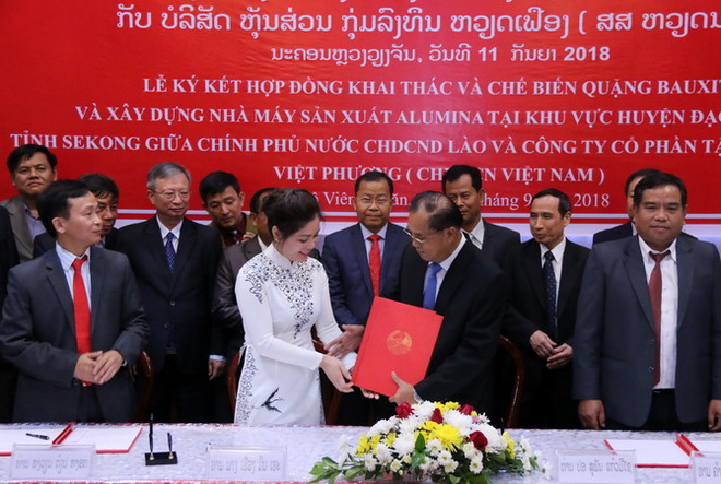 Bộ trưởng Kế hoạch và Đầu tư Lào, ông Suphan Keomisay và bà Phương Minh Huệ, Tổng Giám đốc Tập đoàn đầu tư Việt Phương đang trao cho nhau Hợp đồng tại lễ ký. (Ảnh: Kiên Phạm/Vietnam+) Việt Nam triển khai dự án khai thác mỏ lớn nhất tại Lào ảnh 1