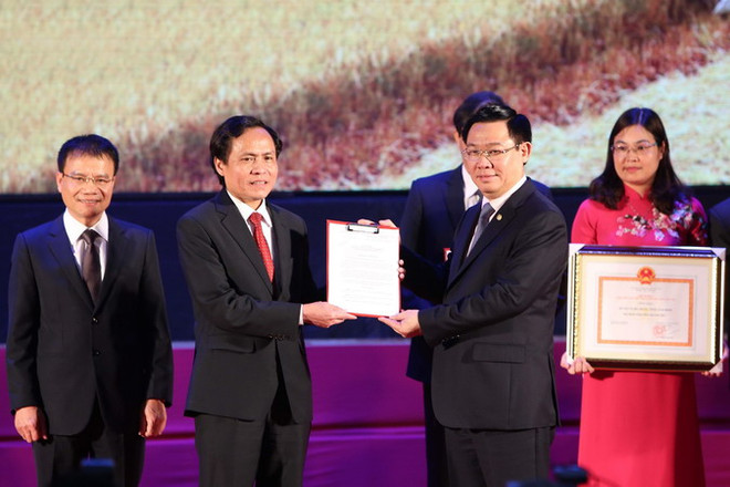 Phó Thủ tướng Vương Đình Huệ trao quyết định đạt chuẩn nông thôn mới cho huyện Nghĩa Hưng. (Ảnh: Dương Giang/TTXVN) Phó Thủ tướng: Tránh tình trạng bê tông hóa, cứng hóa nông thôn ảnh 3