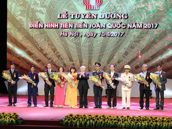 Tổng Bí thư Nguyễn Phú Trọng tặng hoa cho các điển hình tiên tiến. (Ảnh : Phương Hoa/TTXVN) Vinh danh nhiều tấm gương tiêu biểu góp phần xây dựng, bảo vệ Tổ quốc ảnh 1