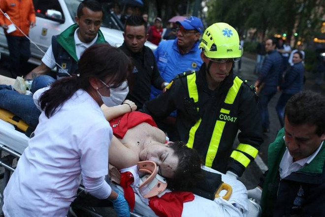 Cấp cứu người bị thương sau vụ đánh bom. (Nguồn: AP) Colombia bắt giữ 8 nghi can vụ đánh bom trung tâm thương mại ảnh 1