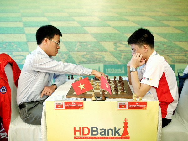 Kỳ thủ Lê Quang Liêm (trái) đấu ván thứ tư với Nguyễn Anh Khôi. (Ảnh: Hoàng Hải/Vietnam+) Kỳ thủ Lê Quang Liêm trở lại tốp đầu tại giải Cờ vua quốc tế ảnh 1