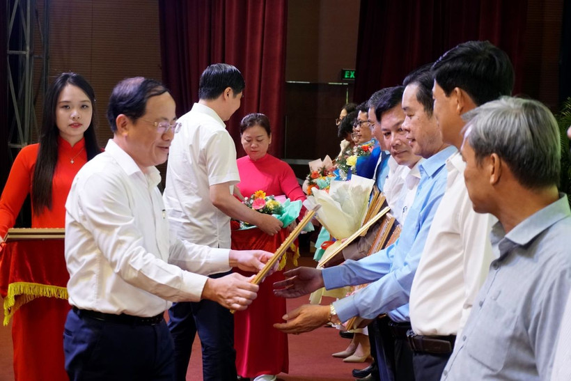 Ông Phạm Anh Tuấn, Chủ tịch UBND tỉnh Bình Định trao bằng khen cho các tập thể, cá nhân có thành tích xuất sắc. (Ảnh: Đình Quân/TTXVN)