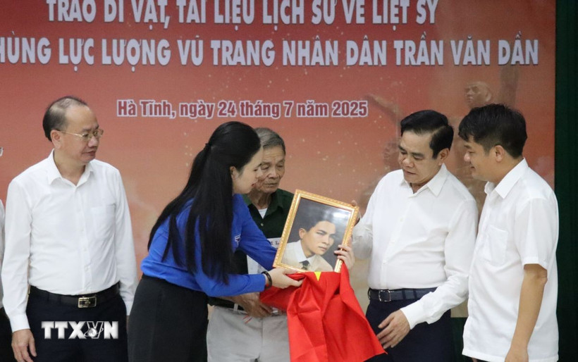 Lãnh đạo tỉnh Hà Tĩnh cùng trao tặng các kỷ vật, tài liệu lịch sử và di ảnh phục dựng của liệt sỹ cho thân nhân gia đình. (Ảnh: Hoàng Ngà/TTXVN)