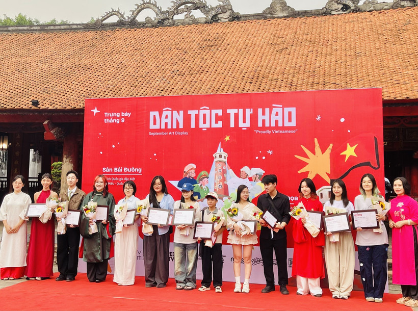 Đại diện Ban tổ chức trao chứng nhận tham gia trưng bày tranh “Dân tộc tự hào” cho các họa sỹ. (Ảnh: Tuyết Mai/TTXVN)