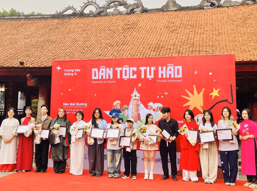 Đại diện Ban tổ chức trao chứng nhận tham gia trưng bày tranh “Dân tộc tự hào” cho các họa sỹ. (Ảnh: Tuyết Mai/TTXVN)