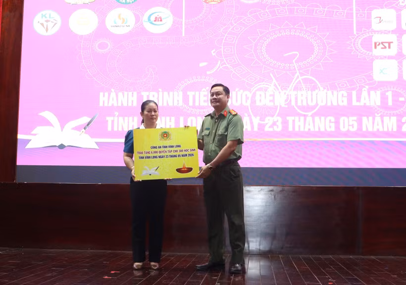 Trao bảng tượng trưng kinh phí hỗ trợ tập cho học sinh. (Ảnh: Lê Thúy Hằng/TTXVN)