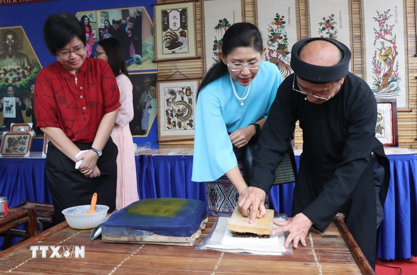 Du khách trải nghiệm in tranh dân gian Đông Hồ. (Ảnh: Thanh Thương/TTXVN)