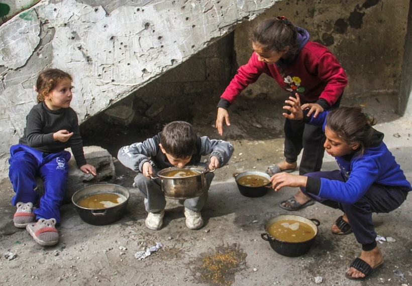 Các em nhỏ được phát thức ăn cứu trợ tại trại tị nạn Al-Shati ở phía Tây thành phố Gaza, ngày 7/12/2024. (Ảnh: THX/TTXVN)