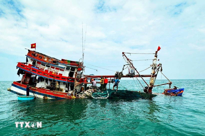 Đồn Biên phòng Hòn Chuối (BĐBP Cà Mau) hỗ trợ cứu vớt tàu cá và ngư dân bị chìm trên biển. (Ảnh: TTXVN phát)