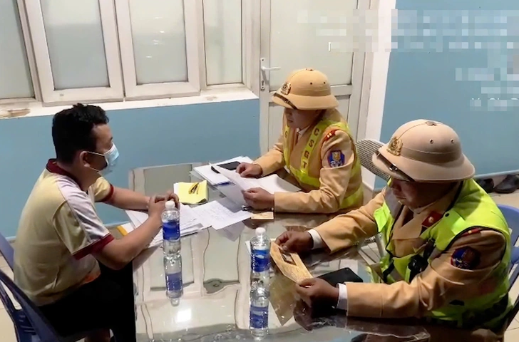 Nam tài xế làm việc với cảnh sát giao thông. (Ảnh: Công an cung cấp)