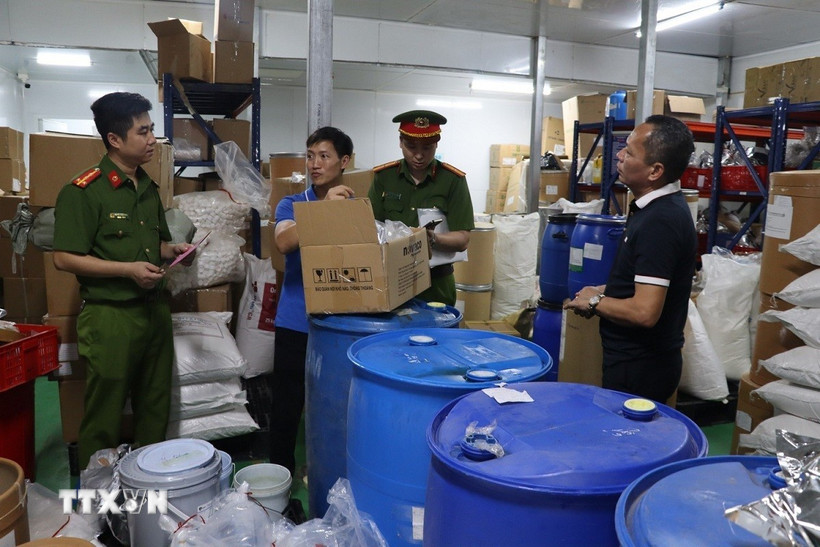 Lực lượng chức năng kiểm tra kho nguyên liệu chế biến các sản phẩm của Gold Care. (Ảnh: TTXVN phát)