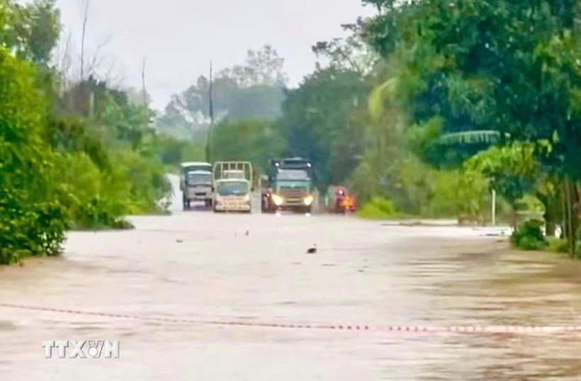 Quốc lộ 29 đoạn qua xã Đức Bình bị ngập sâu, chia cắt giao thông. (Ảnh: TTXVN phát)