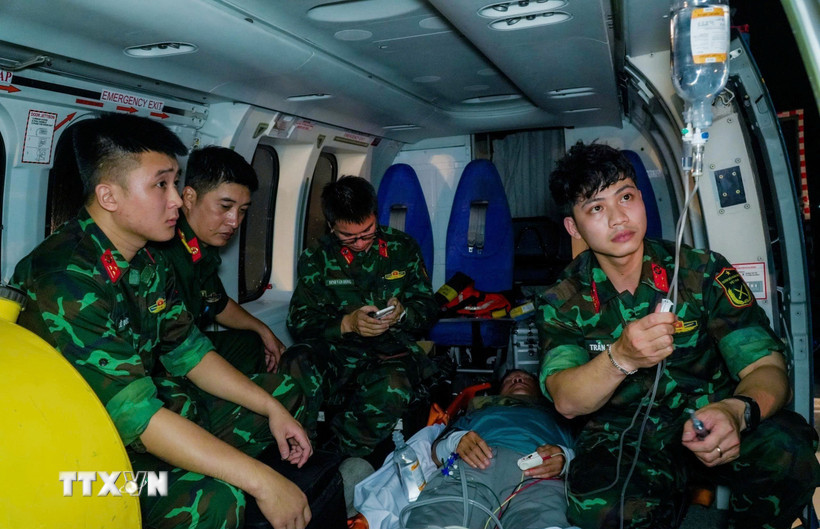 Các bác sỹ Tổ Cấp cứu đường không, Bệnh viện Quân y 175, Thành phố Hồ Chí Minh theo dõi người bệnh trong quá trình bay. (Ảnh: TTXVN phát)
