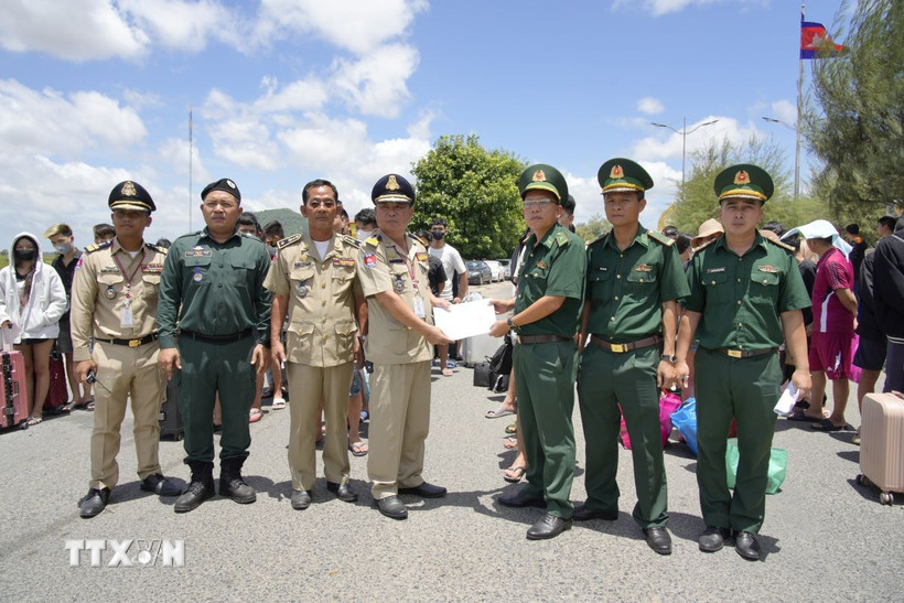 Ban chỉ huy đồn Biên phòng cửa khẩu Quốc tế Tịnh Biên, An Giang (bên phải) ký và trao biên bản giao nhận 72 công dân Việt Nam do phía Campuchia trao trả. (Ảnh: TTXVN)