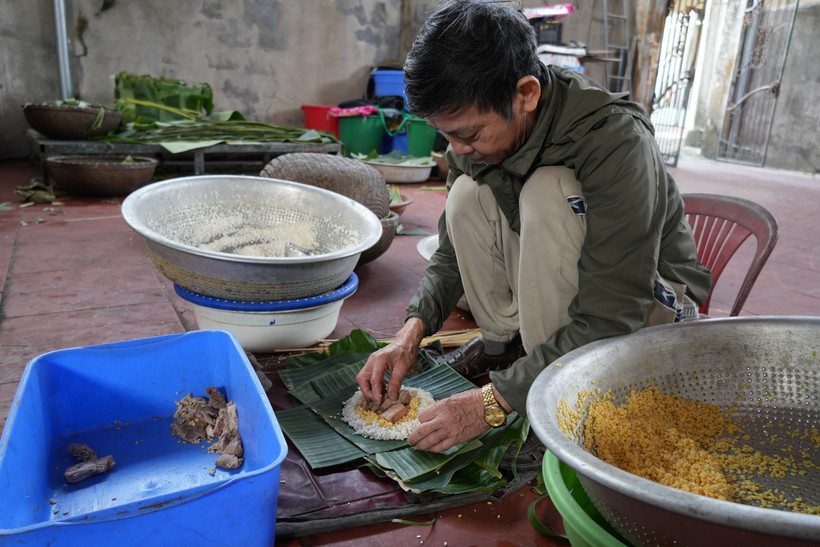 Ông Nguyễn Tất Lớ, làng Thủy Đường, gói bánh. (Ảnh: Tiến Vĩnh/TTXVN)