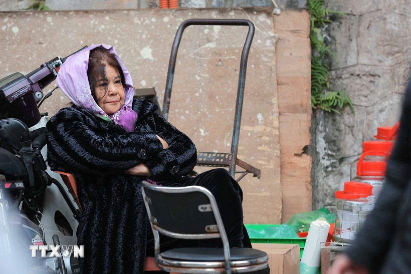 Một người bán hàng co ro trong tiết trời lạnh. (Ảnh: Hoàng Hiếu/TTXVN)