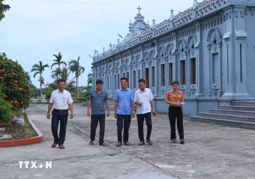 Cán bộ xóm 2, xã Nghĩa Sơn, Ninh Bình tới nhà thờ trên địa bàn để tuyên truyền, vận động người dân đồng thuận với chủ trương sắp xếp, tổ chức lại thôn, tổ dân phố. (Ảnh: Công Luật/TTXVN)