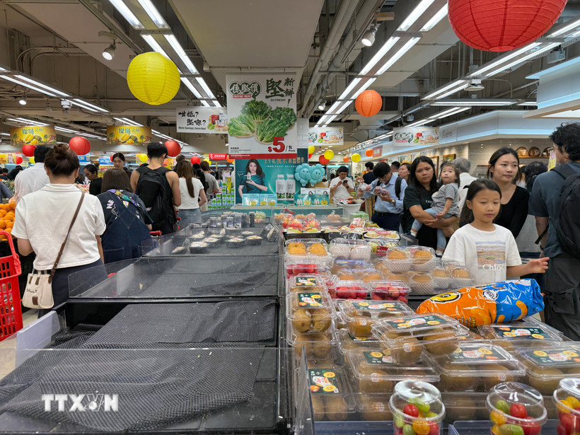 Người dân Hong Kong đổ xô đi siêu thị tích trữ đồ ăn phòng bão Ragasa, tối 22/9. (Ảnh: Mạc Luyện/TTXVN)