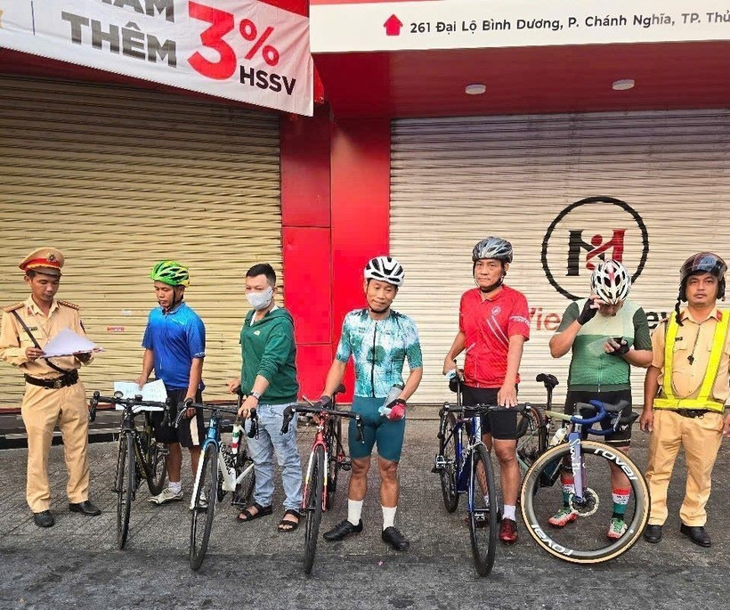 Những trường hợp chạy xe đạp ngang nhiên vượt đèn đỏ bị cảnh sát giao thông Bình Dương lập biên bản xử lý. (Ảnh: TTXVN)