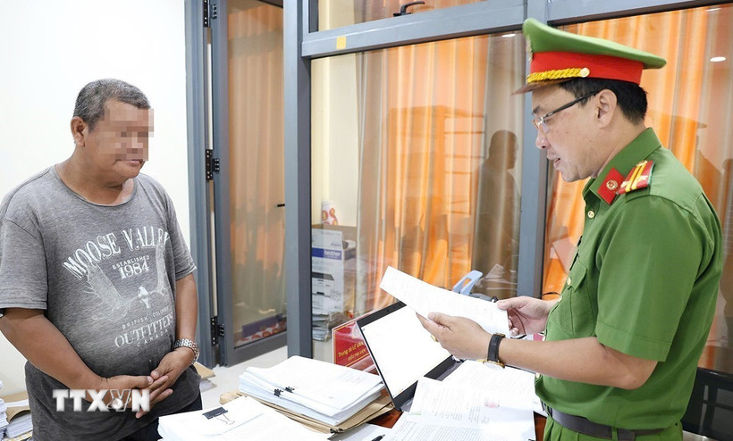 Cơ quan Cảnh sát điều tra Công an tỉnh An Giang tống đạt các Quyết định và Lệnh đối với bị can Đặng Cửu Quí. (Ảnh: TTXVN phát)