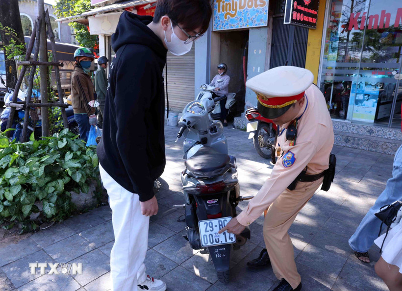 Các trường hợp dán, che biển số khi tham gia giao thông được yêu cầu khôi phục tình trạng ban đầu. (Ảnh: Phạm Kiên/TTXVN)