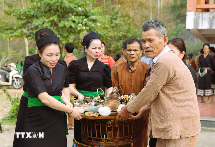 Người dân Ơ Đu di chuyển mâm cúng thần Sấm ra địa điểm cúng được thực hiện ngoài trời. (Ảnh: Xuân Tiến/TTXVN)
