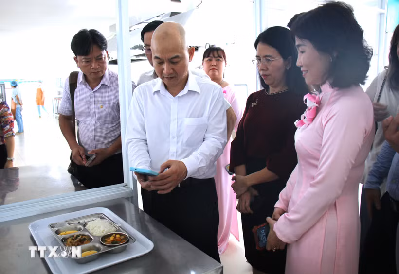 Lãnh đạo Sở Công Thương Thành phố Hồ Chí Minh và đại diện phường Tân Mỹ kiểm tra nguồn gốc thực phẩm từ mã QR tại khay cơm có gắn "Tick xanh trách nhiệm" tại trường Mầm non Phú Mỹ, Thành phố Hồ Chí Minh. (Ảnh: Hương Giang/TTXVN)