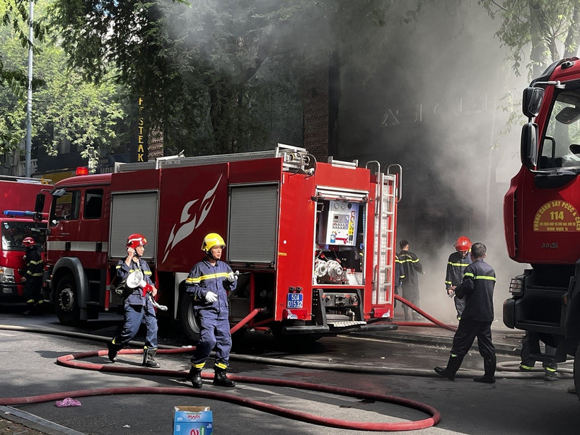 Các lực lượng chức năng tích cực chữa cháy và cứu nạn cứu hộ bên trong quán bar Asi Club. (Ảnh: Thanh Vũ/TTXVN)