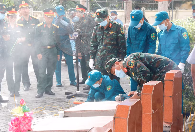 Triển khai quy trình lấy mẫu hài cốt liệt sỹ chưa xác định được thông tin phục vụ giám định AND tại nghĩa trang liệt sỹ xã Đức Linh (Lâm Đồng). (Ảnh: Nguyễn Thanh/TTXVN)