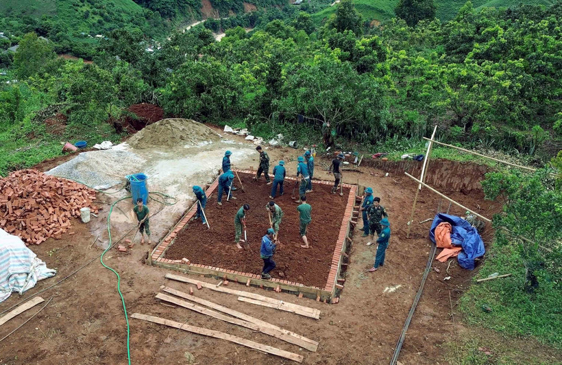Các lực lượng tích cực tham gia xây dựng nhà ở cho nhân dân bị ảnh hưởng, thiệt hại do lũ quét, sạt lở đất trên địa bàn xã Huổi Một. (Ảnh: Quang Quyết/TTXVN)