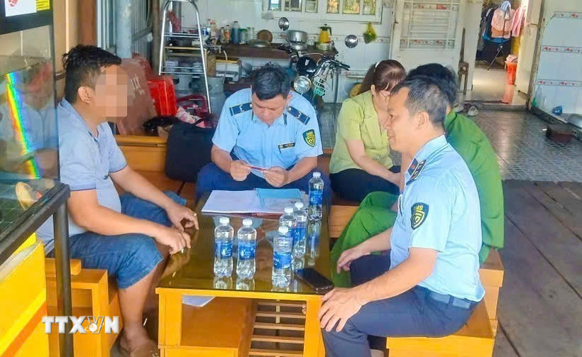 Lực lượng Quản lý thị trường thành phố Cần Thơ làm việc với một cửa hàng xăng dầu sau khi người dân phản ánh. (Ảnh: TTXVN phát)