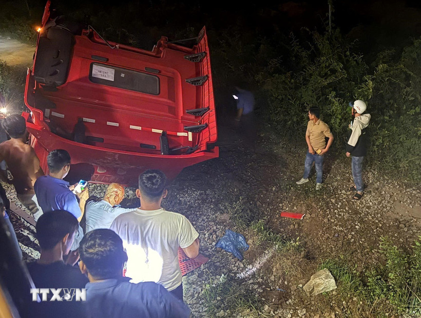 Phần đầu xe tải văng sang một bên đường ray, lật ngửa, biến dạng. (Ảnh: Lê Phước Ngọc/TTXVN)