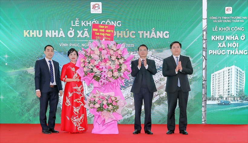 Lãnh đạo tỉnh Vĩnh Phúc tặng hoa cho đại diện Công ty Trách nhiệm Hữu hạn Thương mại và Xây dựng Thân Hà, đơn vị chủ đầu tư Dự án Khu nhà ở xã hội phường Phúc Thắng. (Ảnh: Nguyễn Trọng Lịch/TTXVN)