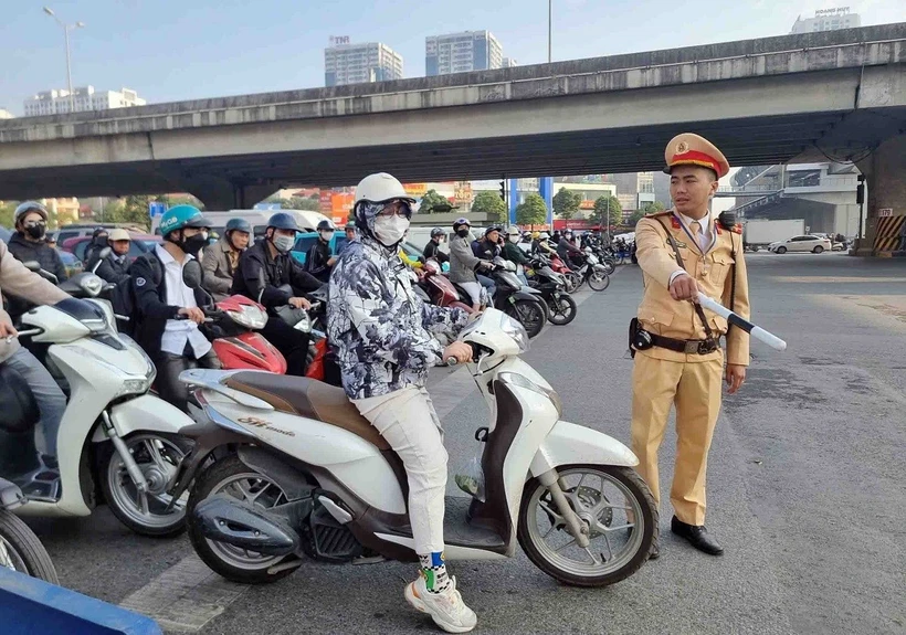 Một trường hợp vi phạm lỗi không chấp hành đèn tín hiệu giao thông bị lực lượng cán bộ, chiến sỹ đội CSGT số 7 dừng xe, kiểm tra và xử lý. (Ảnh: Phạm Kiên/TTXVN)