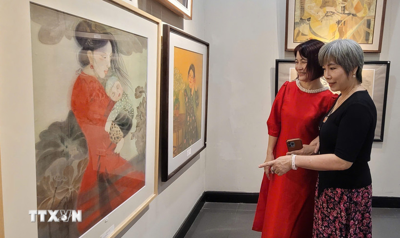 Các nữ họa sỹ tham gia triển lãm tranh. (Ảnh: Phương Thanh/TTXVN)