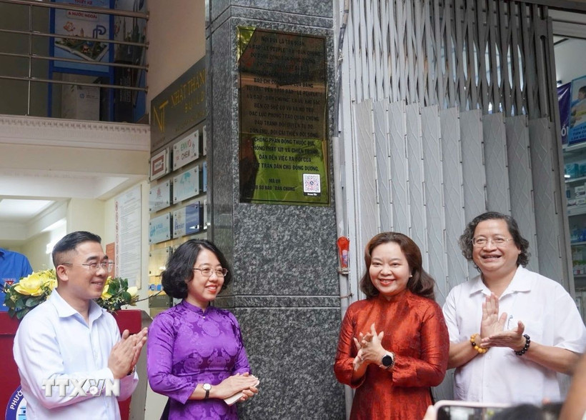 Các đại biểu thực hiện nghi thức ra mắt bảng hiệu Di tích Lịch sử cấp Quốc gia Trụ sở báo Dân Chúng. (Ảnh: Thu Hương/TTXVN)