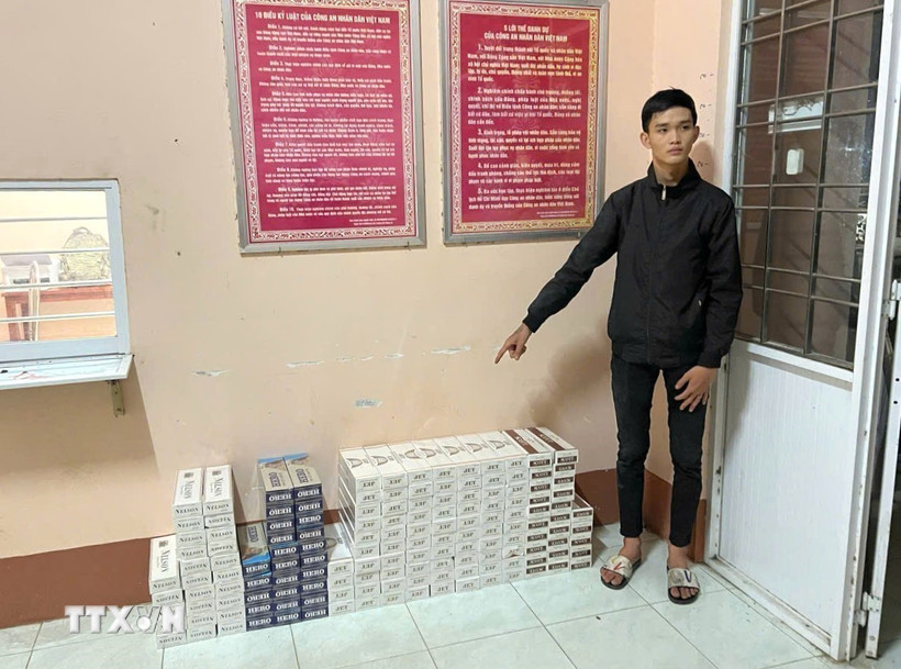 Đối tượng vận chuyển thuốc lá lậu khuya ngày 26/3/2026 bị bắt giữ cùng tang vật. (Ảnh: TTXVN phát)