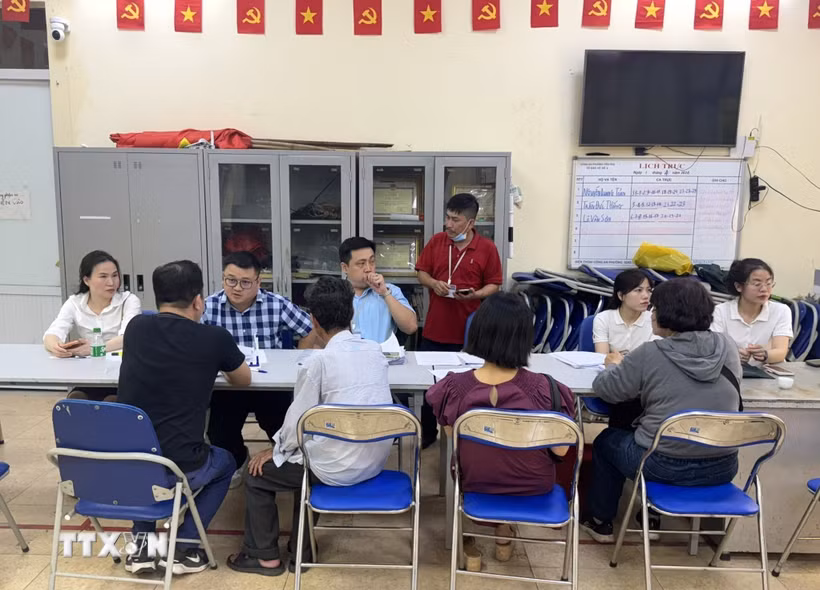 Cán bộ phường Hồng Hà tư vấn giả thích cho người dân đến nhận tiền đền bù giải phóng mặt bằng. (Ảnh: Quốc Lũy/TTXVN)