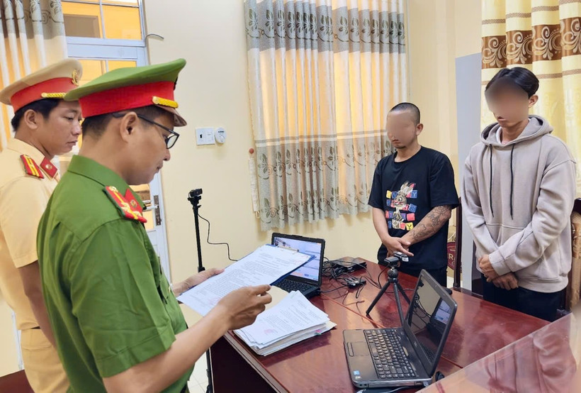 Cơ quan Cảnh sát điều tra tống đạt quyết định khởi tố bị can, lệnh cấm đi khỏi nơi cư trú đối với Võ Duy Khang (áo đen) và Phạm Văn Ý (áo xám)